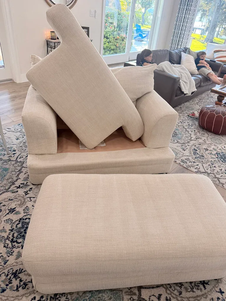 cream armchair cushion propped ottoman blue medallion rug